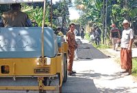 Foto. Kades tengah meninjau realisasikan DD tahap I, pengerjaan pengaspalan hotmix.