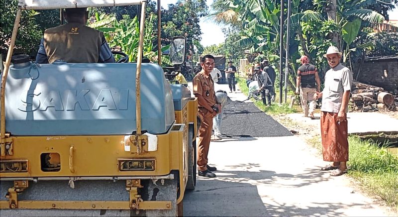Foto. Kades tengah meninjau realisasikan DD tahap I, pengerjaan pengaspalan hotmix.