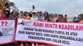 Aksi ibu-ibu dengan membentangkan spanduk bertuliskan. 