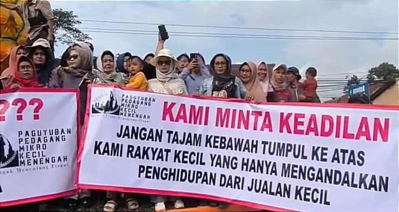 Aksi ibu-ibu dengan membentangkan spanduk bertuliskan. 