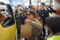 Personel Polisi Wanita (Polwan) bersama prajurit Wanita TNI membagikan paket sembako serta makanan kepada para pemudik yang melintas di Pos Terpadu KM 57.