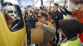 Personel Polisi Wanita (Polwan) bersama prajurit Wanita TNI membagikan paket sembako serta makanan kepada para pemudik yang melintas di Pos Terpadu KM 57.
