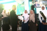 Saat Kepala Madrasah MTsN 2 Subang, Drs. H. Muhamad Toha, memberikan dokumen nilai ke para siswa berprestasi. 