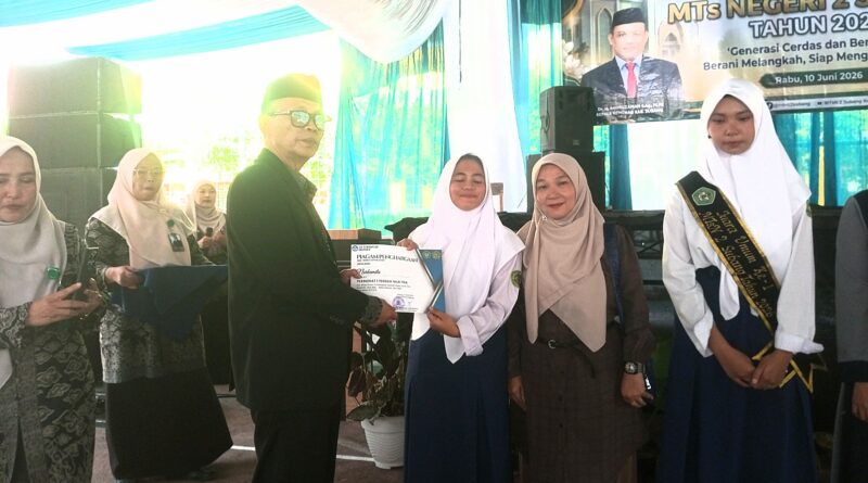 Saat Kepala Madrasah MTsN 2 Subang, Drs. H. Muhamad Toha, memberikan dokumen nilai ke para siswa berprestasi. 